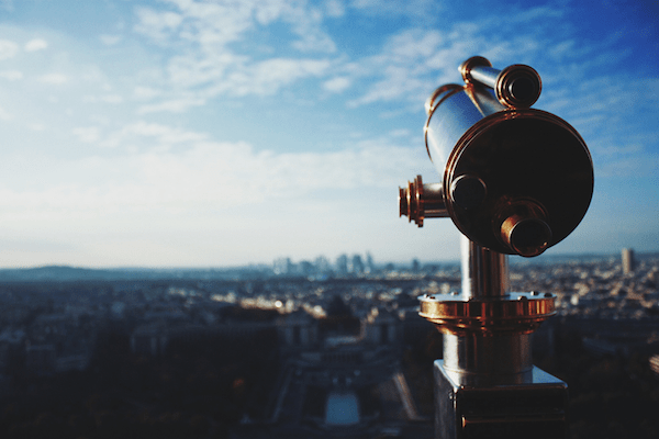 a public telescope overlooking a city landscape