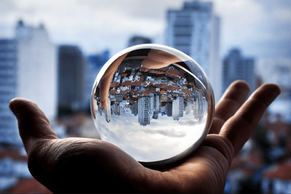 hand holding a snow globe with blurred landscape in the background