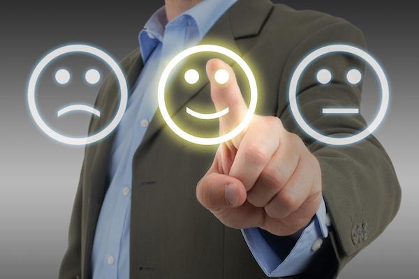 man in suit clicking finger on simple smiley face and not the frowning or neutral face
