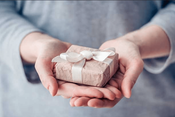 person holding wrapped gift in two hands