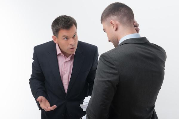 two men in suits. One is chastising and the other looks embarrassed or ashamed