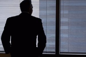 business man silhouetted in window of skyscraper