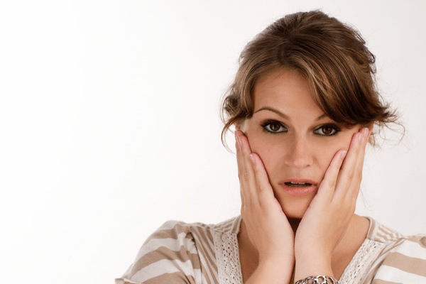 woman holding her face as if in shock