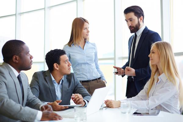 professionals listening to a business man speak