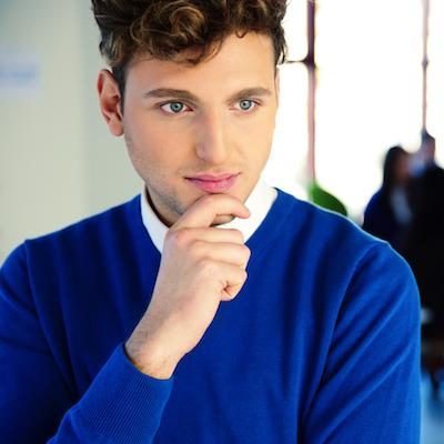 man in sweater with hand on chin looking thoughtful