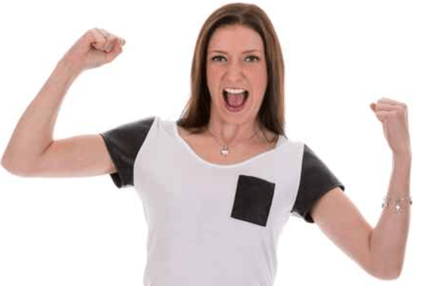woman raising her hands and smiling as if she has won