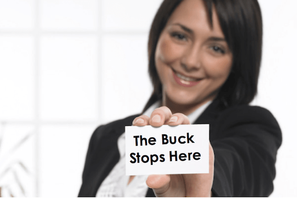 woman holding card out that says the buck stops here