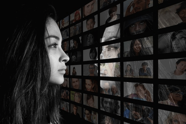 Woman staring at a wall of images of people