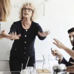 woman trying to calm hostile group of people