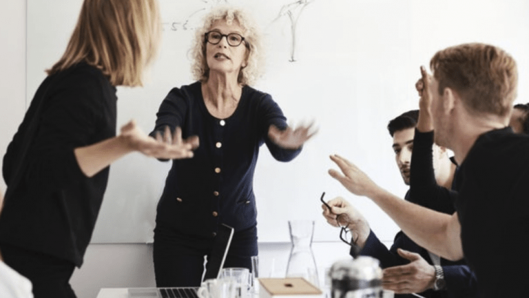 woman trying to calm hostile group of people