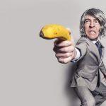 business man wielding a banana like a weapon