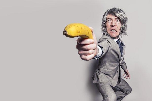 business man wielding a banana like a weapon