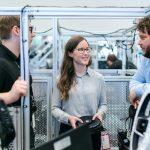 young woman smiling and talking with two younger men