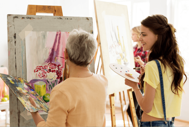 older and younger women painting together