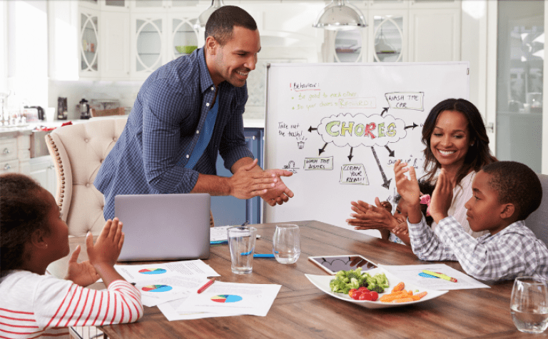 happy family of four clapping over chores