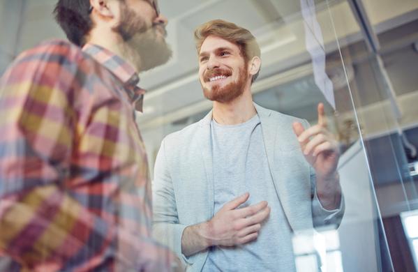 Two men happily collaborating at a board