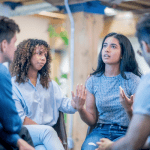 Group of diverse young adults in a circle sharing