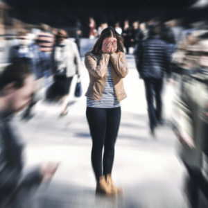 Woman in a blurry crowd looking like she is panicked